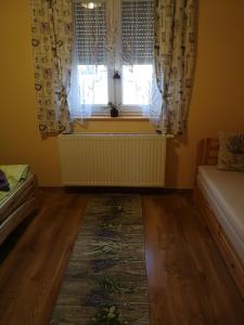 BecsehelyLevendulás ház的一间卧室设有窗户,配有窗帘和地毯