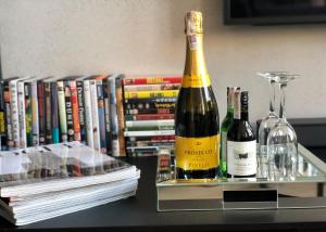 比亚韦斯托克Neon Loft Apartament Bukowskiego的书旁桌子上放两瓶葡萄酒