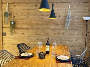 英格堡Apartment SnowKaya by Interhome的一张木桌,配有一瓶葡萄酒和玻璃杯