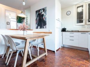 托里代巴拉Apartment Ursula by Interhome的厨房以及带木桌和椅子的用餐室。