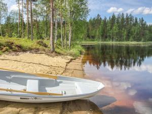 PertunmaaHoliday Home Kurki by Interhome的坐在湖岸上的白船