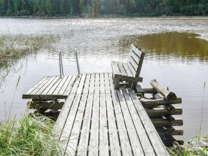 努尔梅斯Holiday Home Haapalehto by Interhome的坐在湖面上的一个船坞上的长凳