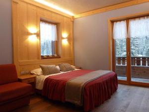 米苏丽娜安托诺湖小屋酒店的一间卧室配有一张床、一把椅子和窗户。