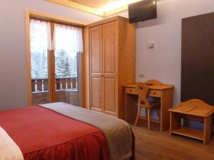 米苏丽娜安托诺湖小屋酒店的一间卧室配有一张床、一张书桌和一个窗户。
