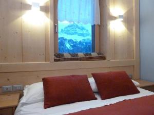 米苏丽娜安托诺湖小屋酒店的一间卧室配有带两个枕头的床和窗户