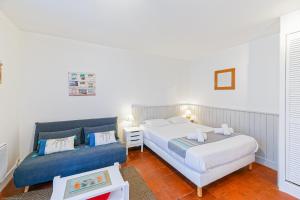 巴约讷Appart'Hôtel Bellevue的一间卧室配有两张床和蓝色的沙发