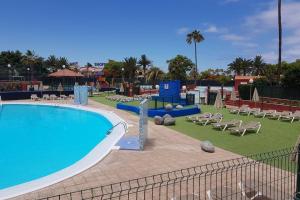 马斯帕洛马斯Sonora Aircon Bungalow 121的一个带椅子的大型游泳池和游乐场
