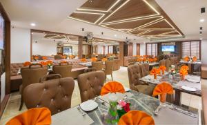 MorbiLords Eco Inn Morbi的餐厅拥有橙色装饰,配有桌椅