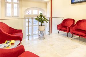 波尔图北方酒店的一间设有红色椅子和盆栽植物的等候室