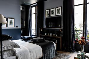 巴黎Monsieur George Hotel & Spa - Champs-Elysées的一间卧室拥有蓝色的墙壁,配有一张带枕头的床。