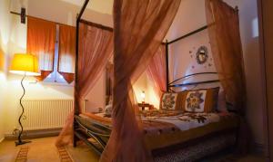 卡托劳塔翁Guesthouse Aelia的一间卧室配有带窗帘和灯的天蓬床