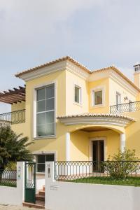法鲁Laguna Formosa - Holidays in Algarve的前面有栅栏的黄色房子