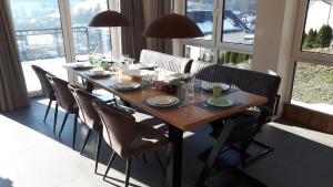 温特贝格Villa Silberberg的餐桌、椅子和大窗户