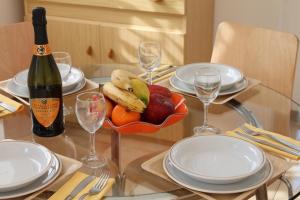 多马索杰拉尼欧住宅酒店的玻璃桌,放上一碗水果和一瓶葡萄酒