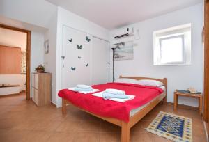 布德瓦Sailor House的一间卧室配有一张带红色毯子的床