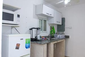 巴拿马城Hostal Familiar Carmencita的厨房配有白色橱柜和白色冰箱。