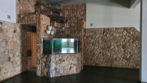 AndradinaDelta Hotel的一间设有石墙和鱼缸的房间