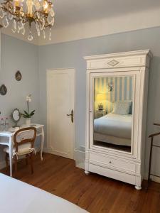 达克斯La Croix Blanche的一间卧室配有一张床、一张桌子和一面镜子