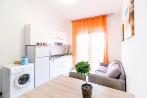 利多迪耶索罗Residence Comfort的厨房以及带桌子和沙发的客厅。