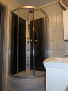 克拉科夫Pokoje Gościnne的浴室里设有玻璃门淋浴