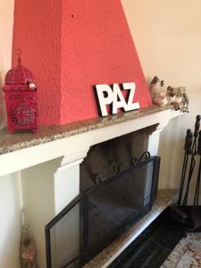 库里提巴Pousada da Paz的红色和白色的壁炉,配有电视