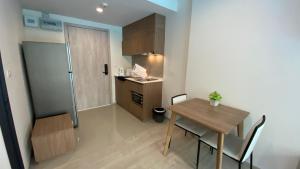 华欣La Casita pool access condo HuaHin的一间小公寓,配有桌子和小厨房