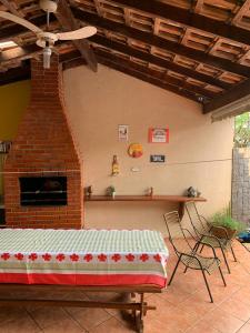 伊瓜苏Casa Da Tiete - Foz do Iguaçu - PR的庭院设有砖砌壁炉、桌子和椅子