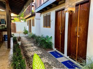 金巴兰Capung Guesthouse的前面有木门和植物的房子