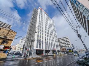 函馆UNIZO INN Express Hakodate Ekimae的一条城市街道上高大的白色建筑