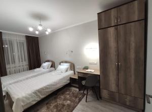 卡拉科尔Lux Apartment Karakol Center的酒店客房配有两张床和一张书桌