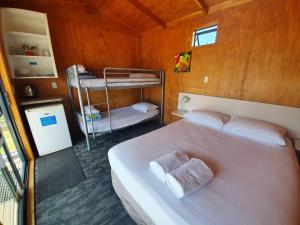 科罗曼德镇Coromandel TOP 10 Holiday Park的一间卧室配有一张带两张双层床的床铺。