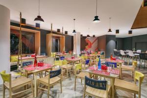 帕纳吉Ginger Goa, Panjim的用餐室配有木桌和椅子