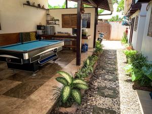 金巴兰Capung Guesthouse的种植了植物的后院的台球桌