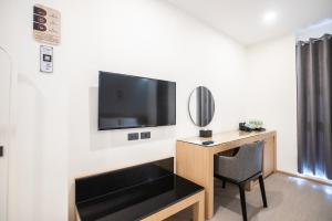 曼谷Cubic Bangna的一间房间,配有一张桌子和一台墙上的电视