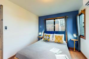 珀拉什奇亚Inn The Trees Cabañas的一间卧室拥有蓝色的墙壁,配有一张带枕头的床。