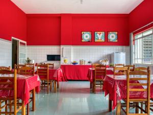 伊塔皮拉Palace Hotel Itapira的一间拥有红色墙壁和木桌及椅子的用餐室
