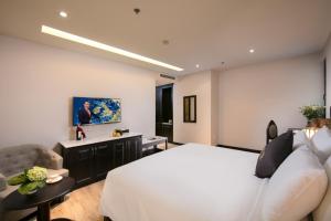 河内Sen Grand Hotel & Spa managed by Sen Group的卧室配有白色的床和沙发