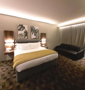 布里茨Copperwood Hotel and Conferencing的酒店客房带一张大床和一把椅子