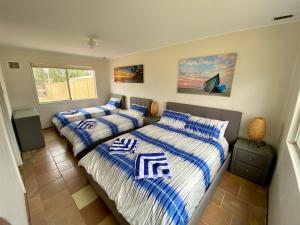 朱里恩湾Central Views的一间卧室配有两张带蓝白色床单的床