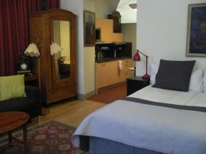 斯德哥尔摩汉密尔顿夫人公寓式酒店的一间卧室配有一张床和一张沙发,还设有一间厨房