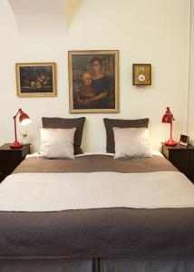 斯德哥尔摩汉密尔顿夫人公寓式酒店的卧室配有一张大床,墙上挂有两张照片