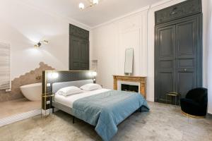 蒙彼利埃Petit Saint Jean的卧室配有1张床、浴缸和1张四柱床。