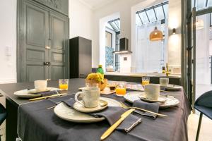 蒙彼利埃Petit Saint Jean的厨房里一张桌子,上面有盘子和餐具