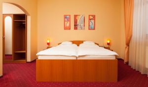 日利纳Penzión Kamélia的一张大床,位于带两个蜡烛的房间