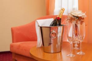 日利纳Penzión Kamélia的桌子上装有一瓶香槟和玻璃杯的桶
