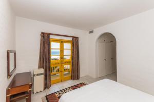 巴利托Santorini - Perissa 32的一间卧室设有一张床,并有通往阳台的门