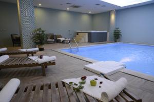 埃尔比勒埃尔比勒克莱西酒店的一个带椅子和桌子的大型游泳池