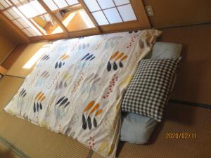 岐阜ゲストハウス山本的小房间的小床,带枕头