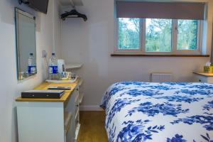 黑尔斯沃思Blyth Lodge B&B的卧室配有蓝色和白色的床和水槽