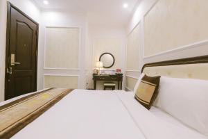 下龙湾Vincent Halong Hotel的卧室配有一张白色大床和镜子